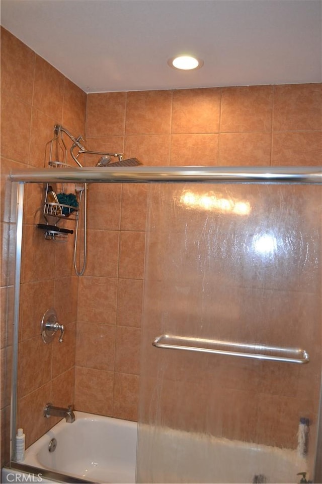 full bathroom with bath / shower combo with glass door