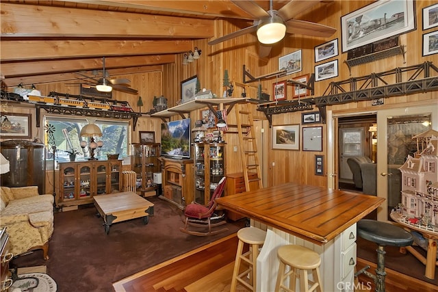 dining area with carpet floors, wood walls, ceiling fan, and vaulted ceiling