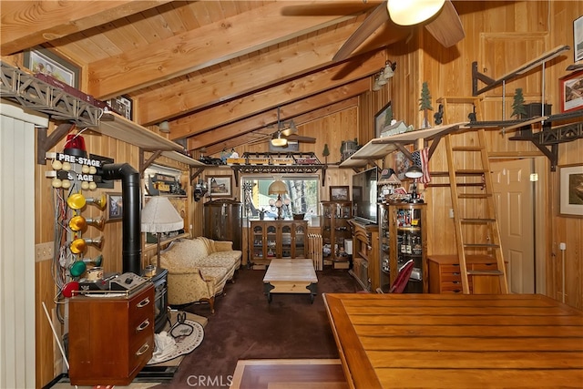 living area featuring vaulted ceiling with beams, a ceiling fan, and wood walls