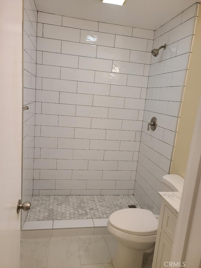 full bath with tiled shower, marble finish floor, toilet, and vanity