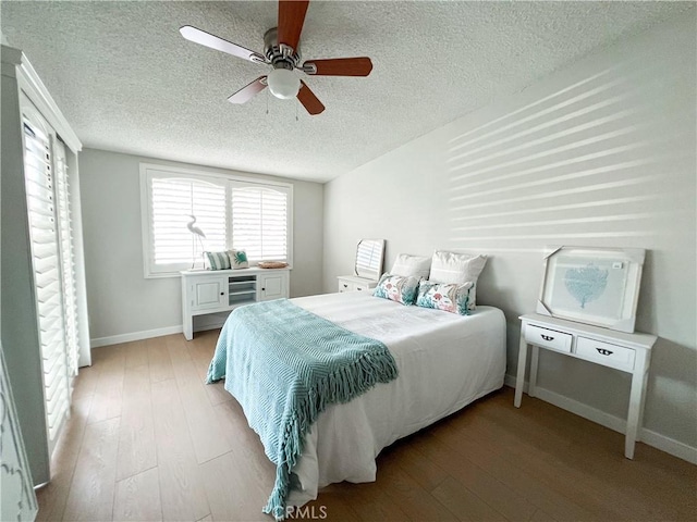 bedroom featuring a textured ceiling, baseboards, ceiling fan, and hardwood / wood-style flooring