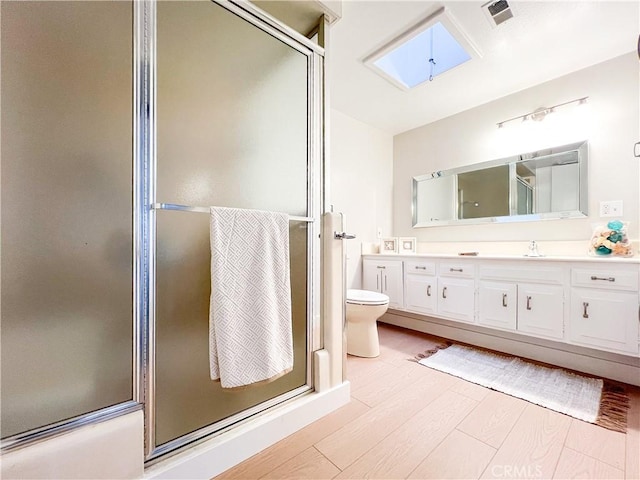 full bath with visible vents, an enclosed shower, a sink, wood finished floors, and double vanity