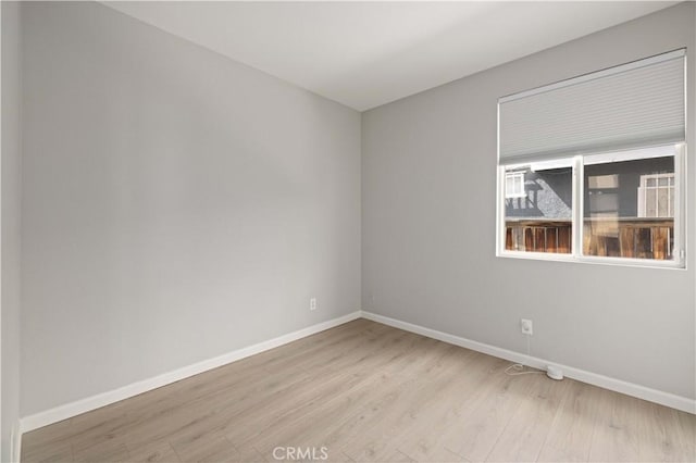 empty room featuring light wood-style flooring and baseboards