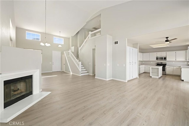 unfurnished living room featuring visible vents, baseboards, and light wood-style flooring