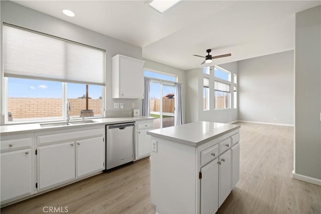 kitchen featuring a sink, light wood-type flooring, dishwasher, and a ceiling fan