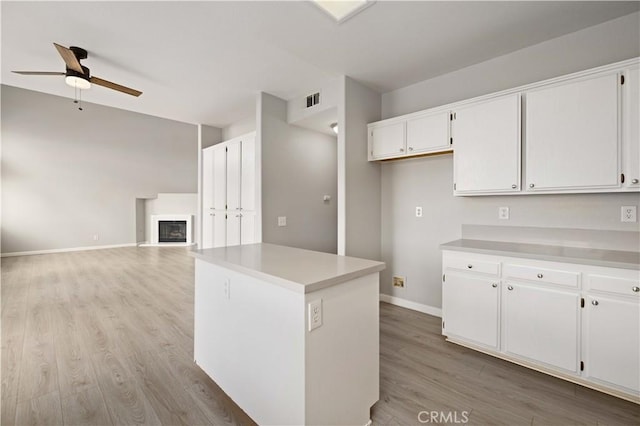 kitchen featuring white cabinets, light wood-style flooring, visible vents, and ceiling fan