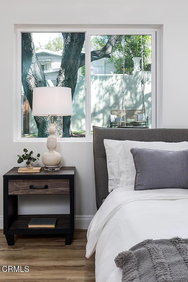 bedroom with wood finished floors and baseboards