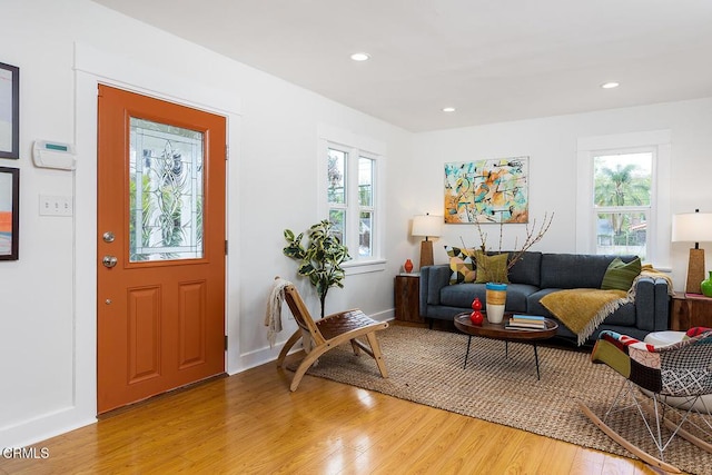 living area featuring recessed lighting, a healthy amount of sunlight, light wood-type flooring, and baseboards