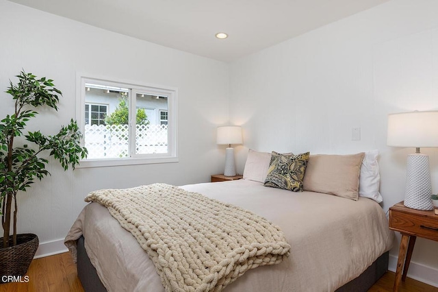 bedroom with recessed lighting, baseboards, and wood finished floors