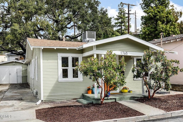 view of front facade featuring a storage unit, central air condition unit, and an outdoor structure