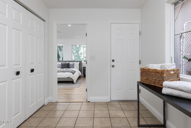 foyer featuring light tile patterned floors and baseboards