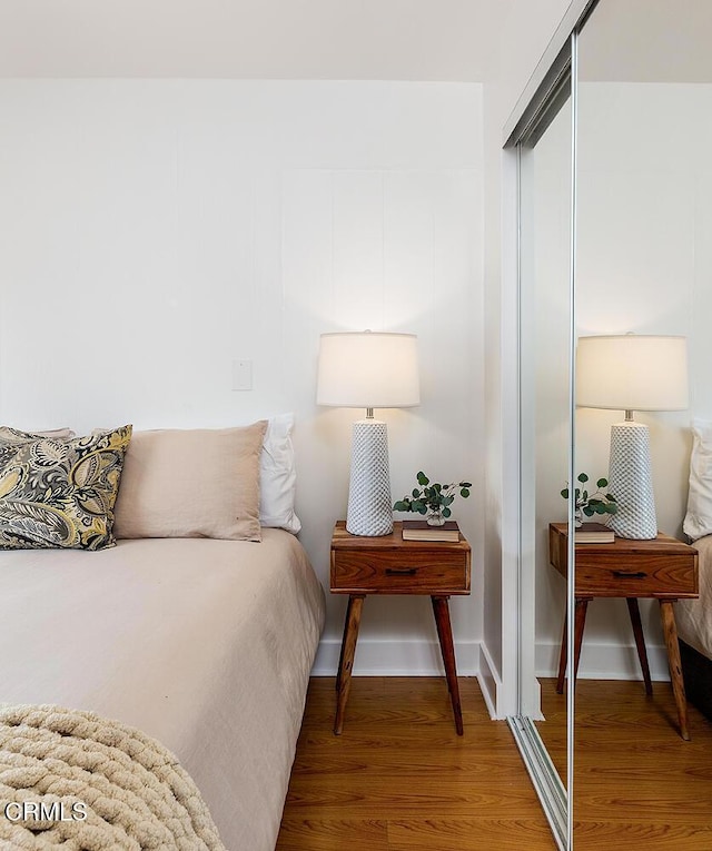 bedroom with a closet, baseboards, and wood finished floors