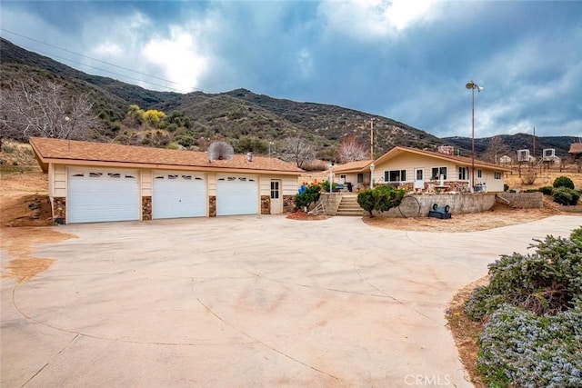 view of front of property featuring a mountain view, concrete driveway, and a garage