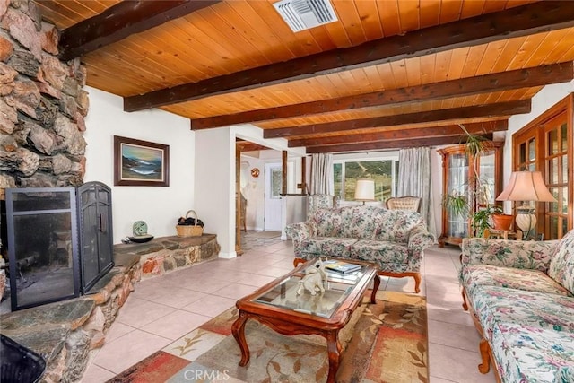 tiled living room featuring visible vents, beamed ceiling, a fireplace, and wood ceiling