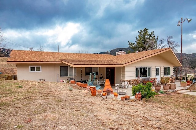 back of property featuring a patio area and a mountain view