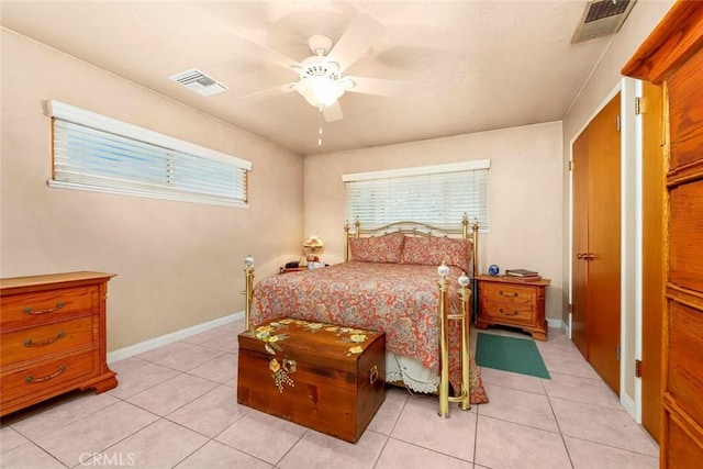 bedroom featuring light tile patterned floors, visible vents, baseboards, and a ceiling fan