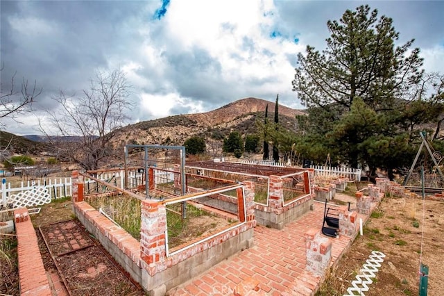 view of yard with a vegetable garden, fence, and a mountain view