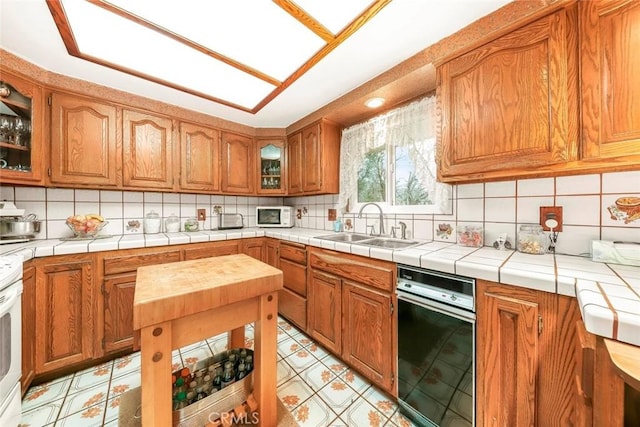 kitchen featuring white microwave, tasteful backsplash, brown cabinetry, and a sink