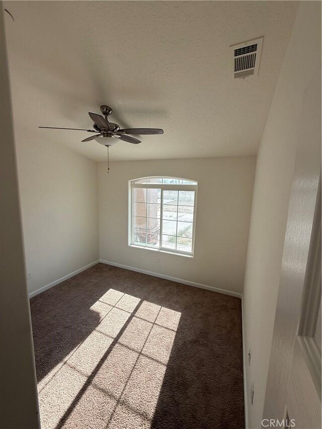 unfurnished room with visible vents, baseboards, a ceiling fan, and carpet floors