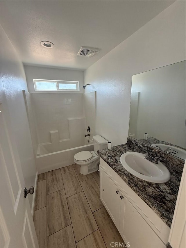 full bath with toilet, vanity, visible vents, wood tiled floor, and tub / shower combination