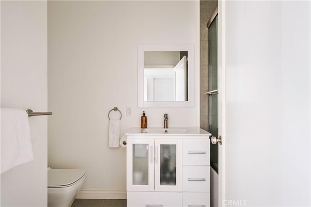 bathroom with vanity, toilet, and baseboards