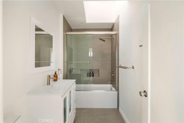 bathroom with tile patterned flooring, vanity, and bath / shower combo with glass door