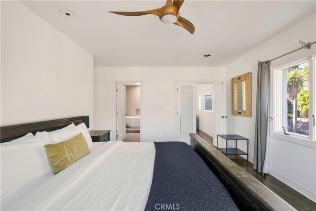 bedroom with connected bathroom, baseboards, dark wood finished floors, and a ceiling fan