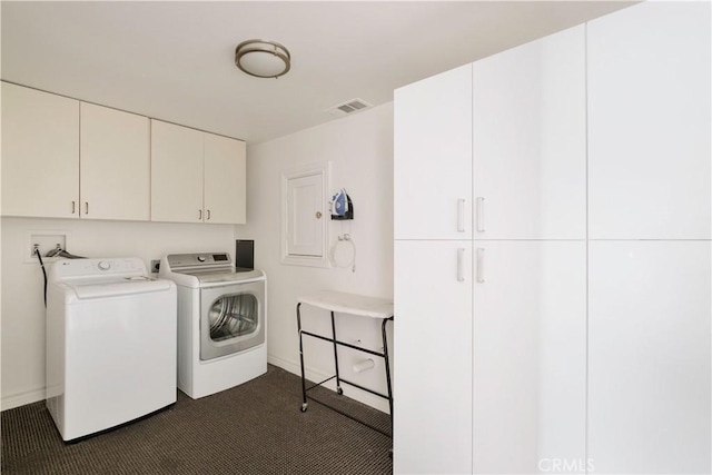 clothes washing area with washer and clothes dryer, visible vents, cabinet space, and baseboards