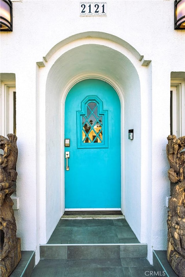 doorway to property featuring stucco siding