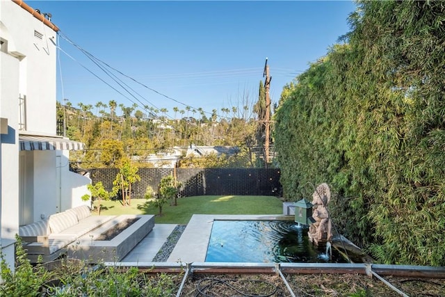 view of pool with fence private yard and a lawn