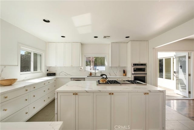 kitchen featuring white cabinetry, a center island, tasteful backsplash, and stainless steel appliances