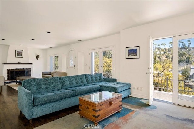 living room featuring baseboards and a brick fireplace