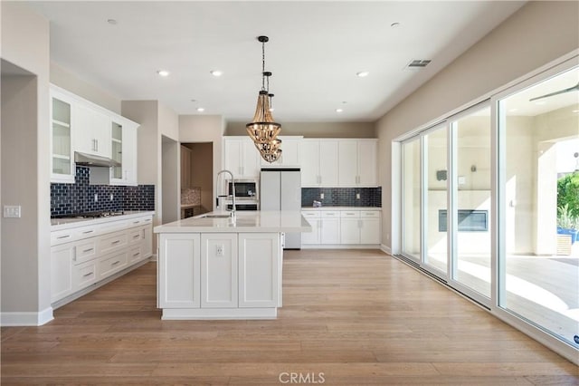 kitchen with visible vents, white fridge, a chandelier, under cabinet range hood, and light countertops