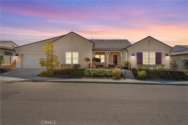 ranch-style home with a garage, driveway, stucco siding, and fence