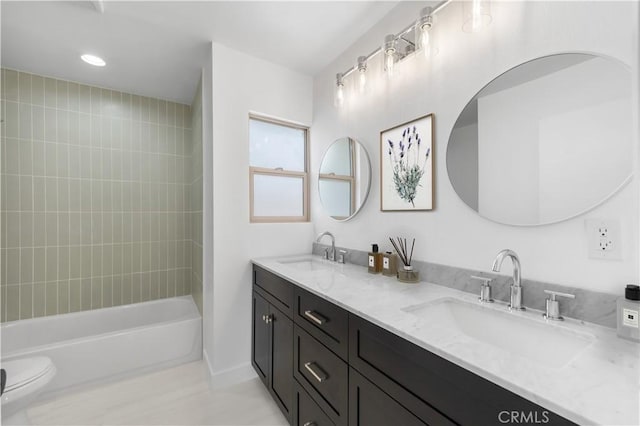 full bathroom featuring double vanity, shower / washtub combination, toilet, and a sink