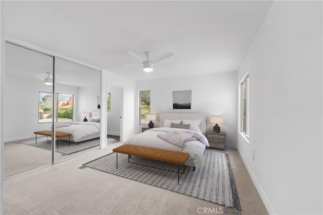 carpeted bedroom with a closet, baseboards, and ceiling fan