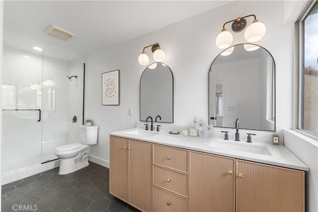 bathroom featuring tile patterned flooring, a shower stall, toilet, and a sink