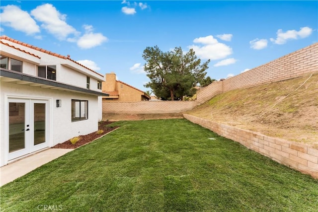 view of yard with french doors and a fenced backyard