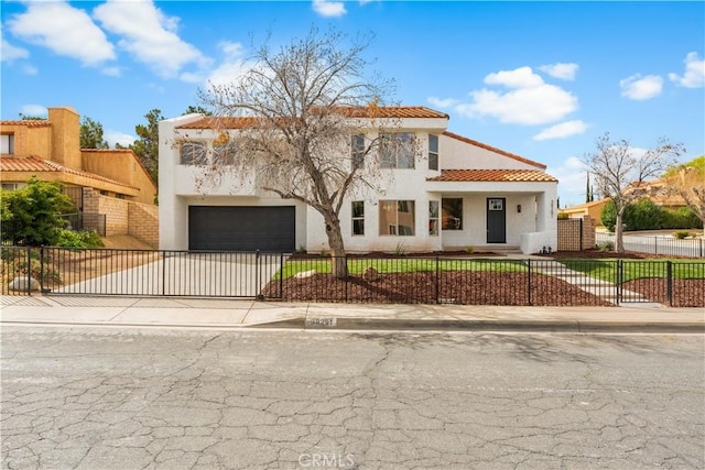 mediterranean / spanish-style house with stucco siding, a fenced front yard, concrete driveway, and a tiled roof