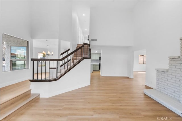 stairway featuring wood finished floors, visible vents, baseboards, an inviting chandelier, and recessed lighting