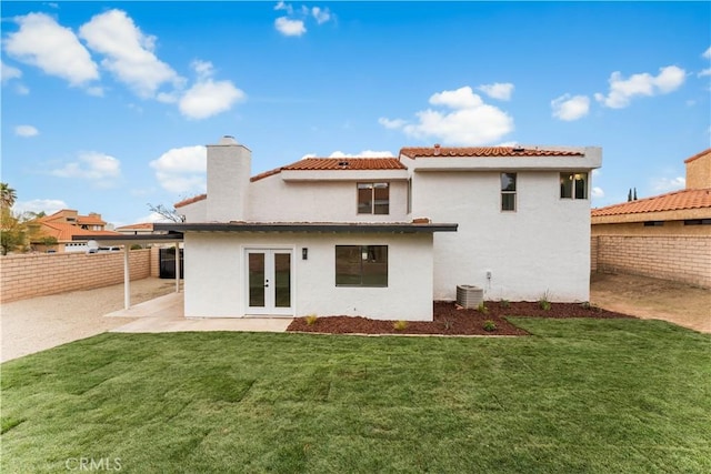 back of property featuring stucco siding, french doors, central AC, and a fenced backyard