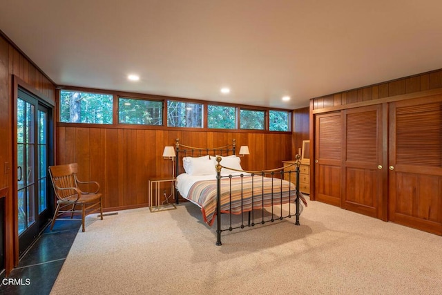 carpeted bedroom featuring wooden walls, recessed lighting, and a closet