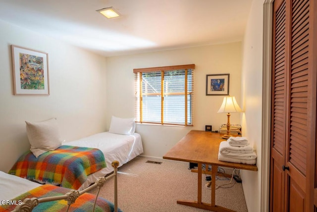 bedroom featuring a closet, visible vents, and carpet