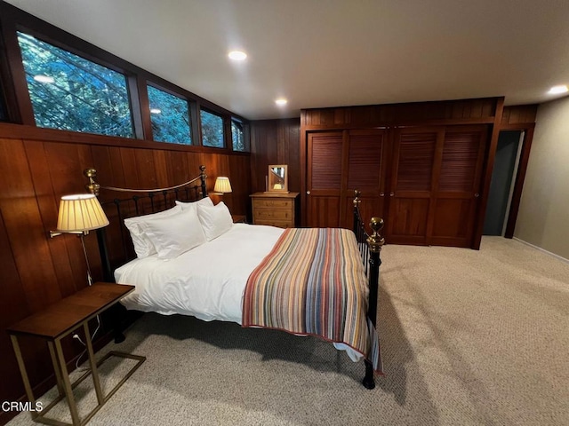 bedroom with recessed lighting, a closet, wood walls, and carpet flooring