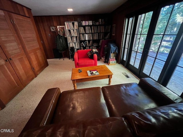 carpeted living area with visible vents and wood walls