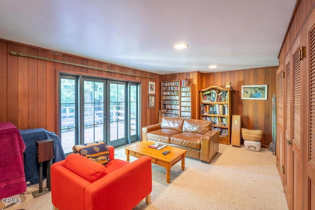 carpeted living area with wood walls