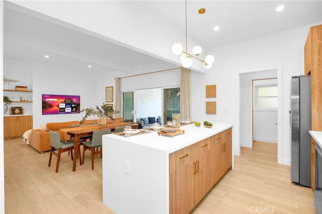 kitchen with light wood-type flooring, recessed lighting, freestanding refrigerator, light countertops, and open floor plan