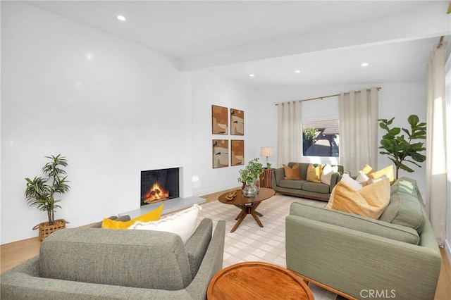 living area featuring recessed lighting, a lit fireplace, and lofted ceiling with beams