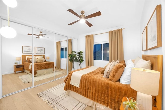 bedroom featuring a closet, light wood-style flooring, and a ceiling fan