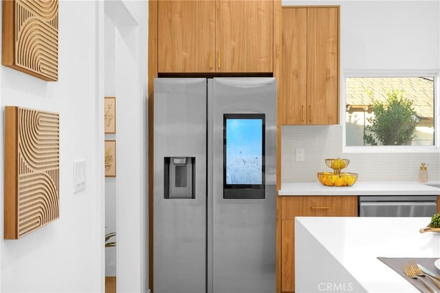 kitchen featuring light countertops, decorative backsplash, brown cabinets, stainless steel appliances, and modern cabinets